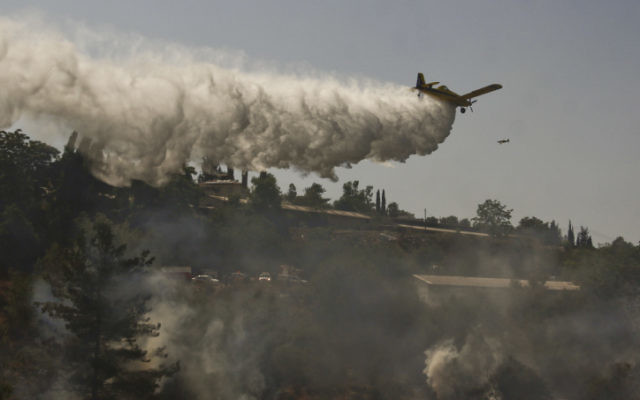 Les pompiers s'efforcent d'éteindre un incendie de forêt qui brûle près du Moshav Even Sapir. (Oren Nahshon/Flash90)