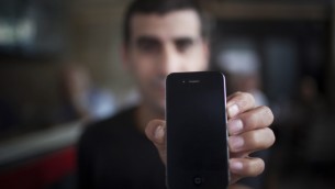An illustrative photo of a man holding an iphone (credit: Yonatan Sindel/Flash90)
