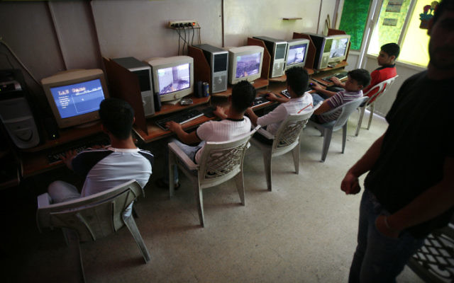 De jeunes Palestiniens devant des ordinateurs dans un cybercafé à Shuafat. (Crédit : Michal Fattal/Flash90)