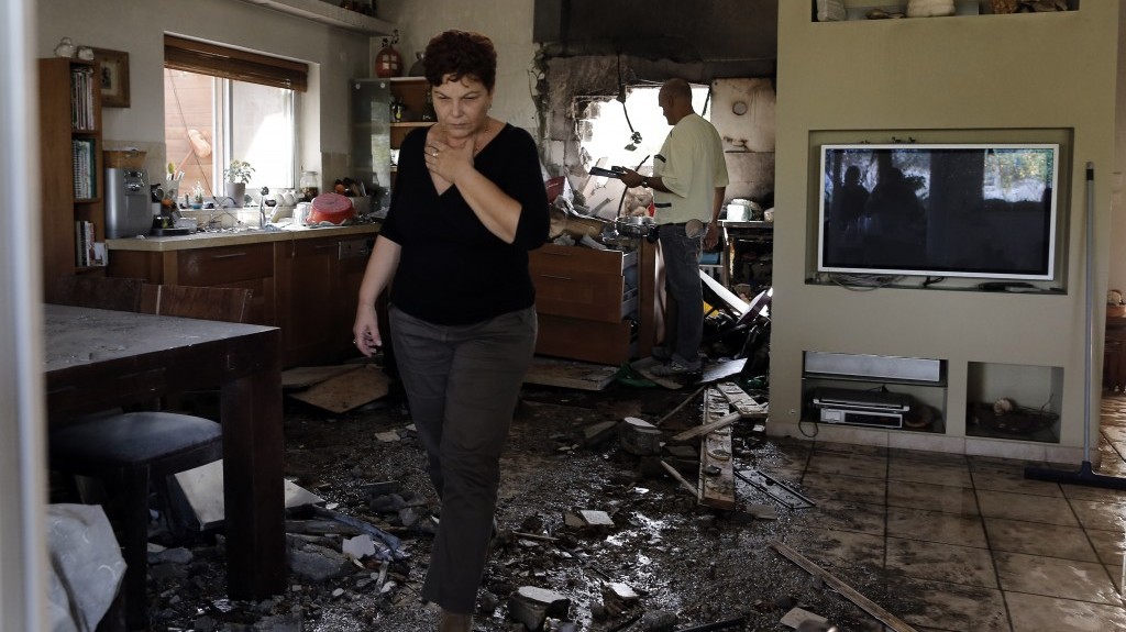 An Israeli woman walks through a house in southern Israel that was hit by a rocket fired from the Gaza Strip during Operation Pillar of Defense (photo credit: Tsafrir Abayov/Flash90)