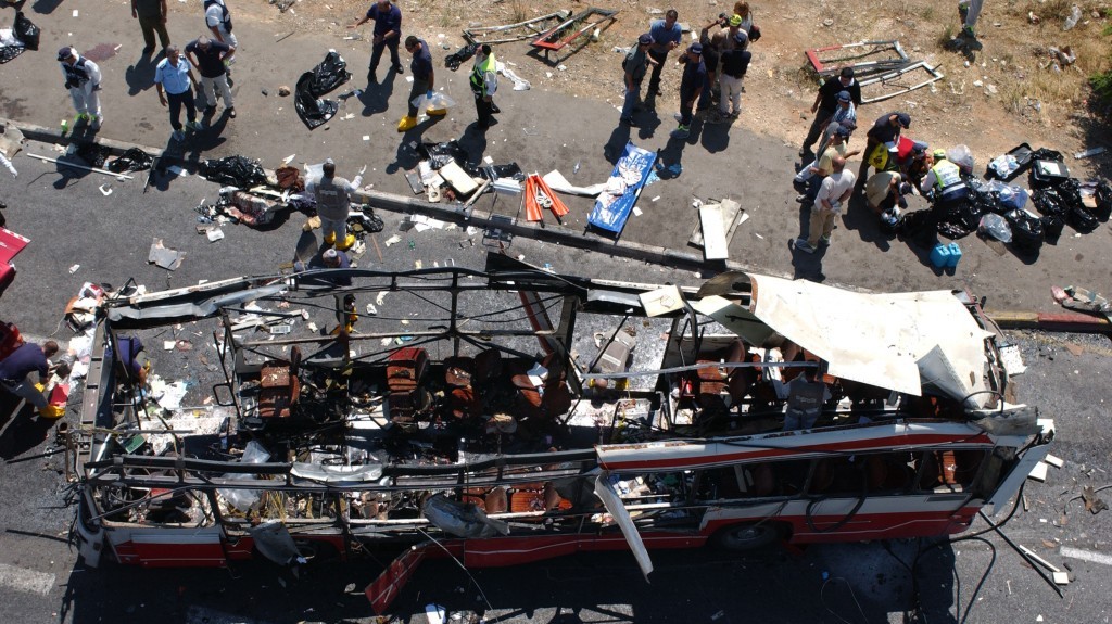 Police and paramedics inspect the scene after a suicide bomber blew himself up on a rush-hour bus near the Jerusalem neighborhood of Gilo during the Second Intifada, on June 18, 2002 (photo credit: Flash90)