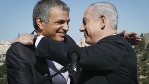 Prime Minister Benjamin Netanyahu embraces outgoing Communications and Welfare Minister Moshe Kahlon, during a press conference on January 21, 2013. (photo credit: Miriam Alster/Flash90)
