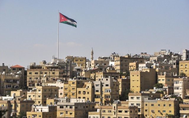Vue d'Amman avec le drapeau jordanien flottant sur la ville. (Crédit : Michal Shmulovich/Times of Israel)