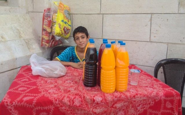 Un jeune résident d'Amman qui installé un stand de jus à l'extérieur d'une mosquée pour que les gens puissent rompre le jeûne (Crédit t: Michal Shmulovich/Times of Israel)