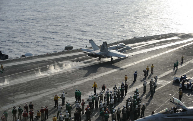 Un avion de combat décolle depuis le poste de pilotage du porte-avions de classe Nimitz USS Dwight D. Eisenhower en Méditerranée, en décembre 2012 (Crédit : CC BY-NC-ND Département américain de la Défense, Flickr)