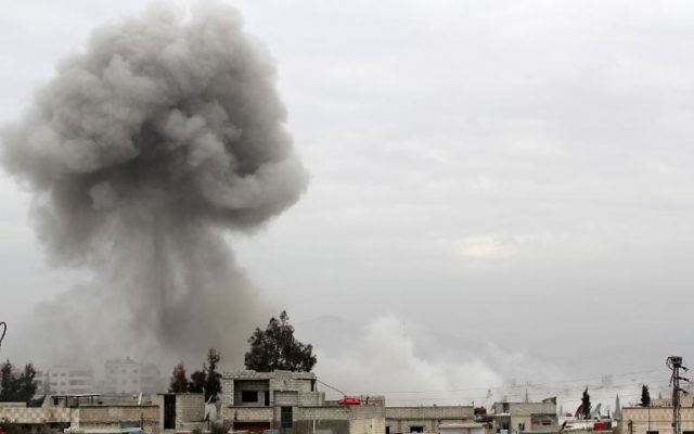 De la fumée au-dessus d'immeubles après une attaque aérienne de l'armée syrienne, le 25 janvier 2014 à Daraya, au sud-ouest de Damas (Crédit : AFP/Fadi Dirani)