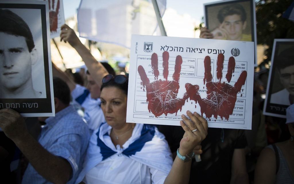 Manifestants israéliens protestant contre la libération de prisonniers palestiniens en août 2013. Il est écrit sur la pancarte : Formulaire de sortie de prison (Crédit  : Flash 90)