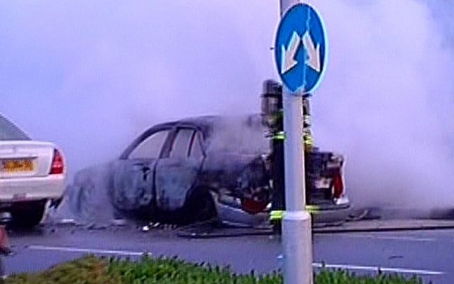 La coque carbonisée d'une voiture, visée par une bombe à Tel Aviv (Crédit :  Channel 2 capture d'écran)