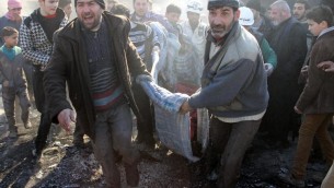 Des hommes transportent une victime, après un bombardement sur la ville d'Alep, le 1er février 2014  (Crédit : AMC/AFP Zein Al-Rifai)