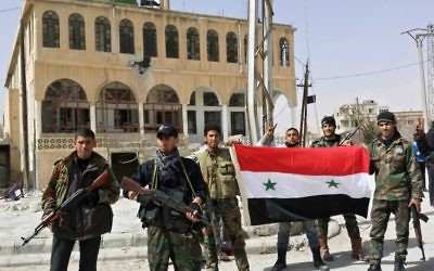 Des soldats pro-gouvernement affichent le drapeau syrien et posent pour une photo dans le village d'al-Sahel, près de Yabroud (Crédit : AFP/STR)