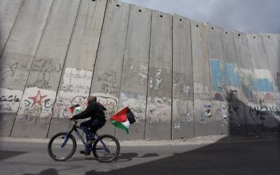 Une Palestinienne roule le long du mur de séparation près du quartier de al-Aizaria à Jérusalem, le 1er mars 2013 (Crédit : Issam Rimawi/Flash90)