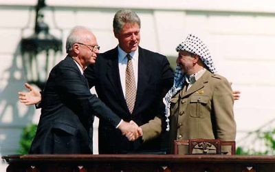 La poignée de main entre Yitzhak Rabin et Yasser Arafat, accompagnés de Bill Clinton, après la signature des Accords d'Oslo, le 13 septembre 1993. (Crédit : Vince Musi/The White House/Wikimedia commons)