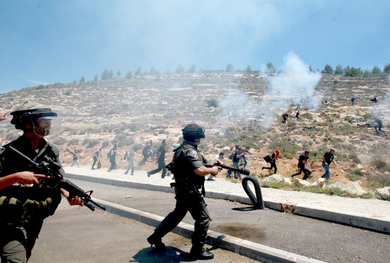 Gardes-frontières israéliens pendant des affrontements contre des manifestants palestiniens commémorant le 66e anniversaire de la "Nakba" dans le village de Walajah, en Cisjordanie, au sud de Jérusalem, le 15 mai 2014. (Crédit : Musa al-Shaer/AFP)