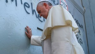 Le pape fait une prière devant la barrière de sécurité (Crédit : AFP)