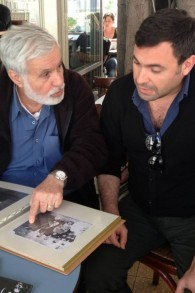 Moshe Zaki montre à son fils Uri un album de famille (Crédit : Renee Zhert Gand)
