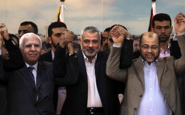 De gauche à droite : le chef de la délégation du Fatah Azzam al-Ahmad, le Premier ministre du Hamas dans la bande de Gaza Ismael Haniyeh et Abu Marzouk, le jour de la signature du pacte de réconciliation entre les deux factions palestiniennes, le 23 avril 2014. (Crédit : Said Khatib/AFP)