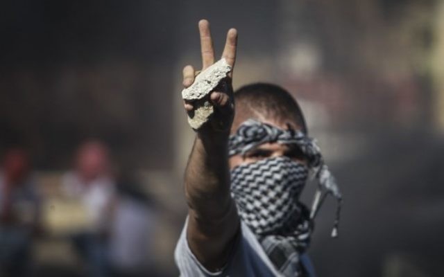 Un activiste palestinien lance des pierres à la police israélienne à Shuafat - 2 juillet 2014 (Crédit : Hadas Parush/Flash90)