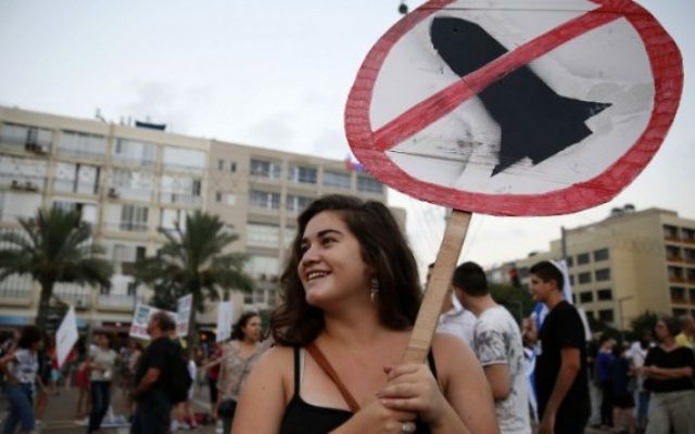 Des Israéliens se rassemblent lors d'une manifestation appelant le gouvernement et l'armée pour mettre fin aux tirs de roquettes palestiniens de Gaza une fois pour toutes, à Tel Aviv le 14 août, 2014 (Crédit : AFP / GALI TIBBON)