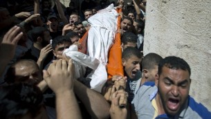  Des palestiniens portent le corps de l'un des trois commandants du Hamas lors de leur enterrement dans le sud de la bande de Gaza à Rafah, le 21 août, 2014 (Crédit : AFP Photo / Mahmud Hams) 