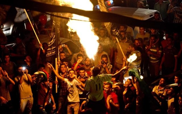 Un Palestinien souffle le feu tandis que les Gazaouis se rassemblent pour célébrer le cessez-le-feu entre Israël et le Hamas le 26 août, 2014  dans la ville de Gaza. (Crédit : AFP PHOTO / ROBERTO SCHMIDT)