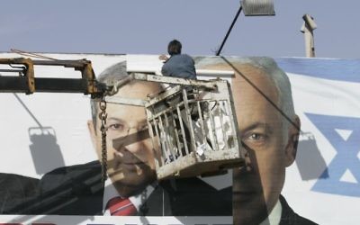 Des ouvriers remplaçant une affiche de campagne du Parti travailliste avec une du Likud à Jérusalem, le 30 janvier 2009 (Crédit : Yossi Zamir / Flash90)