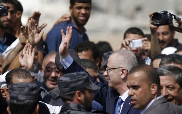 Le Premier ministre de l'Autorité palestinienne Rami Hamdallah (C) salue les gens lors d'une visite dans le quartier Chajaya la ville de Gaza, le 9 O
octobre, 2014. (Crédit : Saïd Khatib / AFP)