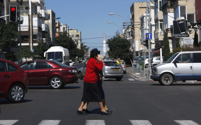Les piétons peuvent être distraits par leur portable lorsqu'ils traversent la rue (Crédit : Nati Shohat/Flash90)
