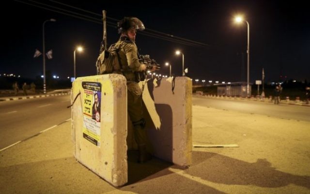 Un soldat israélien à Alon Shvut, près de l'endroit  où a été assassinée Dahlia Lemkus le 10 novembre 2014 (Crédit : Nati Shohat/Flash90)