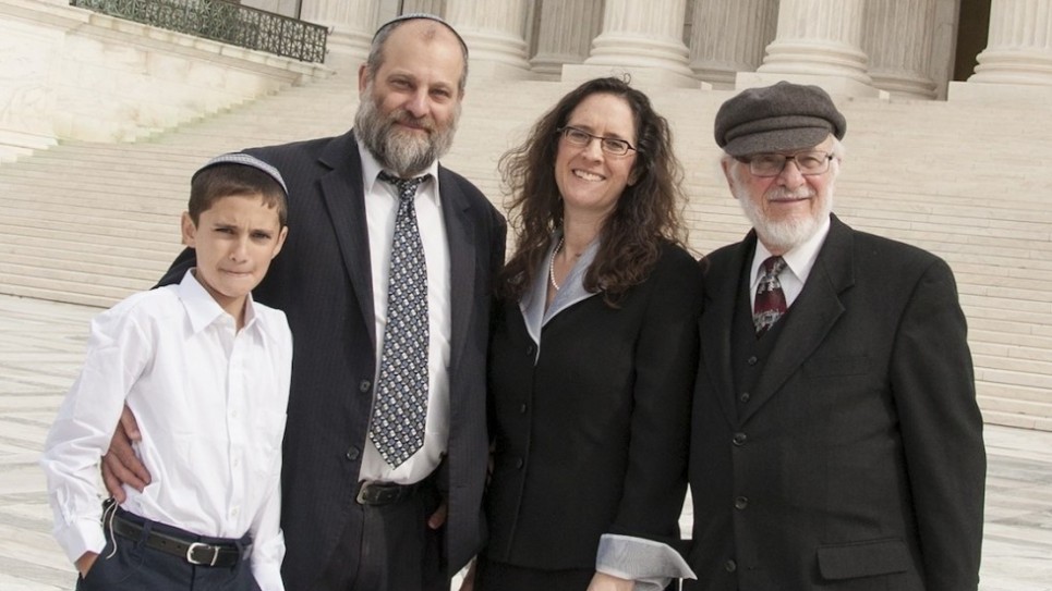 Menachem Zivotofsky, à gauche, et son père Ari posant devant la Cour suprême à son avocat Alyza Lewin et le père de Nathan Lewin, le 3 novembre 2014 (Crédit : Rikki Gordon Lewin)