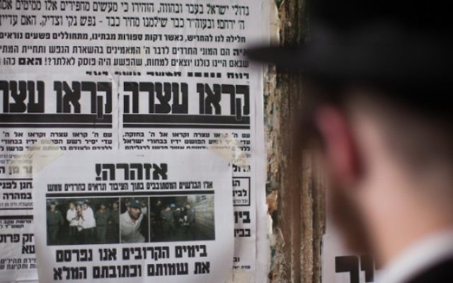 Un Juif ultra-orthodoxe lisant un "Pashkvil" - une affiche d'information - dans le quartier de Méa Shearim, le 19 août 2014 à Jérusalem (Crédit photo: Yonatan Sindel / Flash90)