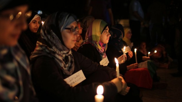 Femmes voilées à Gaza tenant des cierges lors d'une manifestation le 16 août 2013 (Crédit : Flash90/Wissam Nassar)