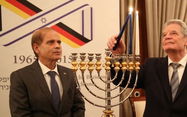 L'ambassadeur israélien en Allemagne, Yakov Hadas-Handelsman, regardant le président allemand qui allume une menorah lors d'une cérémonie (Crédit :  ministère des Affaires étrangères )