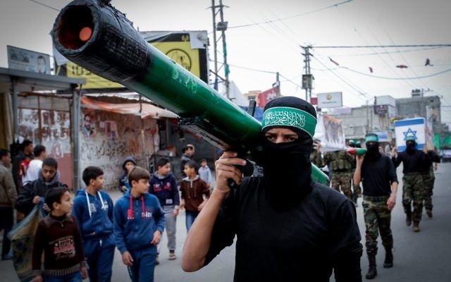 Un homme masqué du Hamas portant une fausse roquette (Crédit : Abed Rahim Khatib/Flash90)