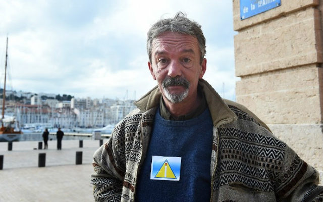 Arnaud, un homme sans-abri, porte un "badge de sécurité" lors d'une manifestation en face de l'Hôtel de Ville de Marseille, sud de la France, le 3 décembre, 2014. (Crédit : AFP / Anne-Christine Poujoulat)