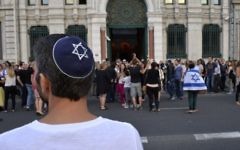 Illustration: Un homme avec une kippa regarde les gens prendre part à une manifestation organisée par le CRIF devant la synagogue de Lyon, le 31 Juillet 2014. (Crédit : Romain Lafabregue/AFP)