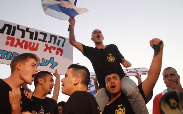 Des jeunes de l'association Lehava avec des pancartes sur lesquelles on peut lire "L'assimilation est un Holocauste" devant un mariage judéo-musulman près de Tel Aviv, le 17 août 2014. (Crédit : Flash90)