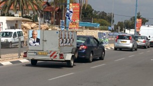 Un petit camion avec des affiches du Premier ministre Benjamin Netanyahu placardé dessus conduisant dans les rues de la ville du sud de Sderot (Crédit : Ilan Ben Zion/Times of Israel)