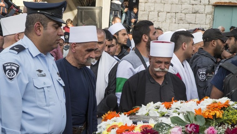 Les amis, les parents et les dignitaires religieux pleurent devant le cercueil de l'agent de police israélien Zidan Saif, 30 ans, membre de la communauté druze d'Israël, lors de ses obsèques dans son village de Yanouh-Jat, le 19 novembre 2014 (Crédit : AFP / Jack Guez)