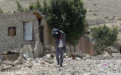 Un homme transporte ses affaires après que sa maison ait été bombardée - Yémen - 22 avril 2015 (Crédit : AFP)