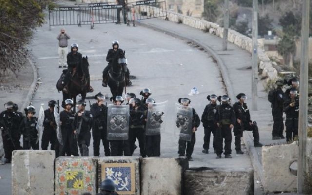 La police des frontières israélienne monte la garde à côté de nouveaux blocs de ciment placés à l'entrée d'Issawiya à Jérusalem-Est lors d'une manifestation contre la fermeture du quartier, le 12 novembre 2014 (Crédit : Hadas Parush / Flash90)