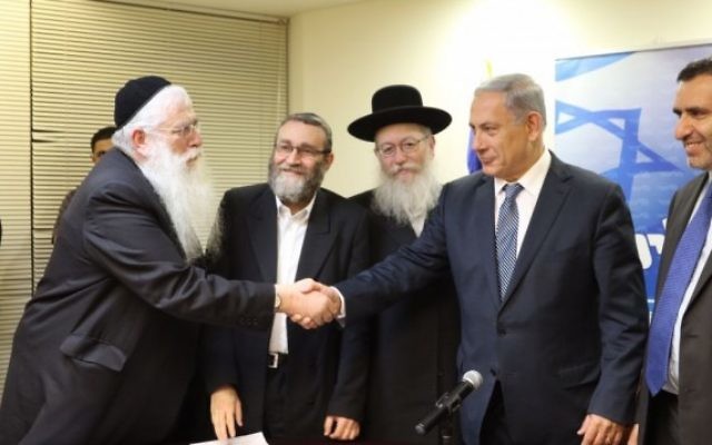 Les chefs de file du Likud, Benjamin Netanyahu, et de Yahadout HaTorah, Yaakov Litzman, se serrent la main, le 29 avril 2015. (Crédit : Autorisation, Likud)