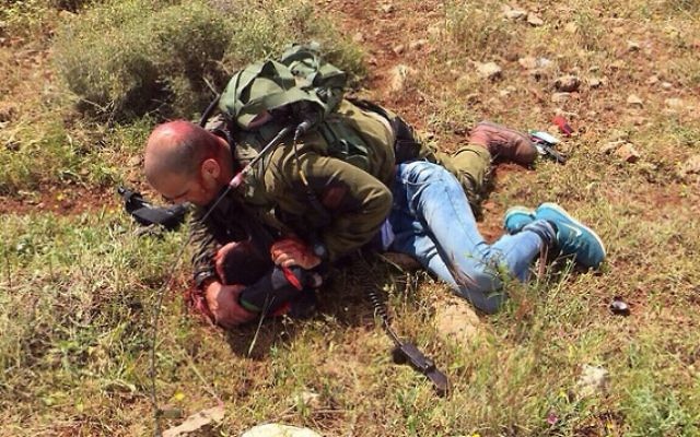 Un soldat israélien neutralise un Palestinien qui a poignardé un autre soldat près de la barrière de sécurité en Cisjordanie, le 2 avril 2015. (Crédit : Porte-parole de Tsahal)