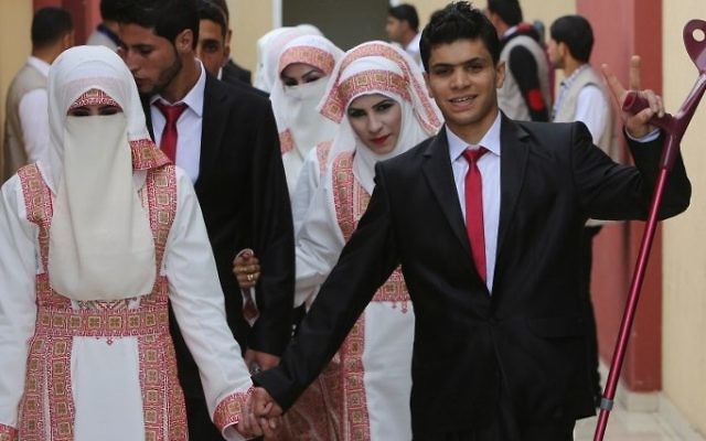 Une mariée palestinienne Marwa Mousa et son fiancé Ahmed Abou Salama prennent part à une cérémonie de mariage de masse dans la ville de Gaza, le 11 avril, 2015. (Crédit : AFP / MAHMUD HAMS)