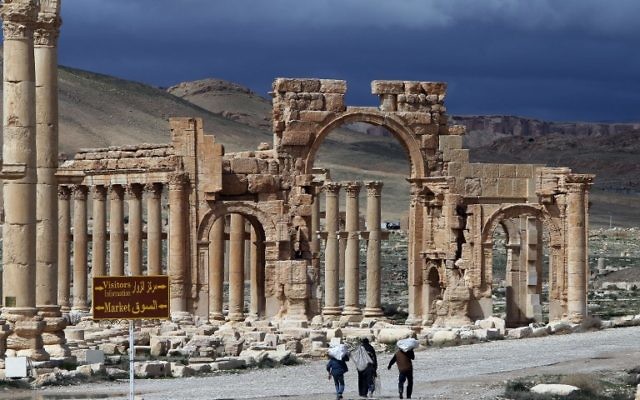 Une photo prise le 14 mars 2014 montre des citoyens syriens marchant dans la ville antique de Palmyre, à 215 km au nord-est de Damas. L'État islamique (EI), qui se vante d'avoir détruit des sites antiques en Irak, menace l'ancien joyau de Palmyre, un site inscrit au patrimoine mondial de l'UNESCO, le 14 mai 2015 (Crédit : AFP PHOTO / JOSEPH EID)