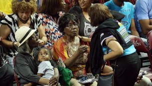 Des membres de la famille des victimes pendant la veillée funèbre au College of Charleston TD Arena  (Crédit : Chip Somodevilla/Getty Images/AFP)