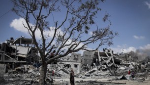 Des Palestiniens ramassent leurs effets dans les maisons détruites par les bombardements israéliens dans le nord de la bande de Gaza, à Beit Lahiya, le mardi 4 août 2014. (Crédit : Emad Nasser / Flash90)