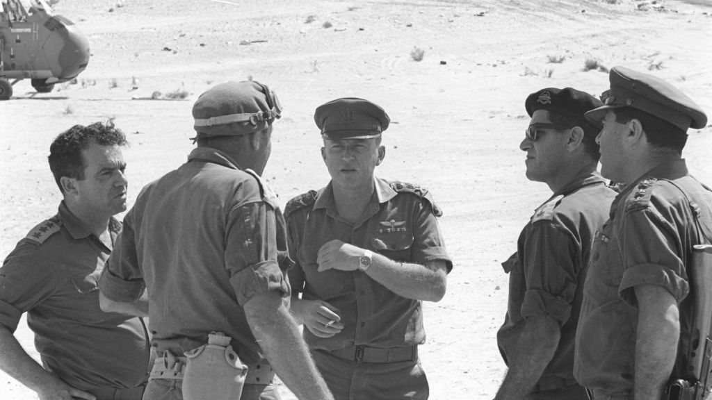 Yitzhak Rabin, au centre avec une casquette, le chef d'état-major de Tsahal, au cours de la guerre des Six Jours, en parlant avec le commandant de la région sud Yeshayahu Gavish (Crédit : Autorisation d'Israel Defense Force Archive)