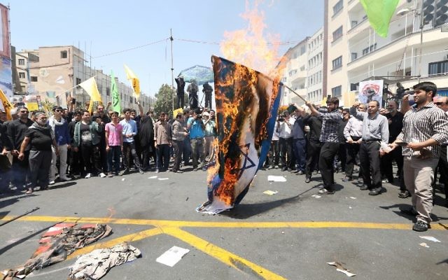 Des manifestants iraniens brûlent un drapeau israélien lors d'une manifestation pour marquer la journée internationale de Al Qods (Jérusalem) à Téhéran le 10 juillet 2015. (Crédit : AFP / ATTA KENARE)