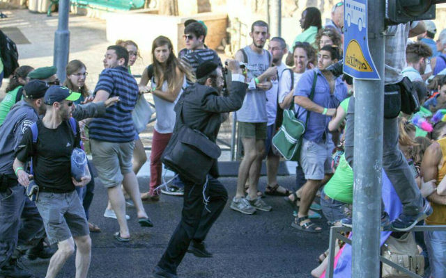 Les participants de la Gay Pride à Jérusalem fuient l'homme au couteau, Yishai Schlissel, le 30 juillet 2015. (Crédit : Koby Shotz)