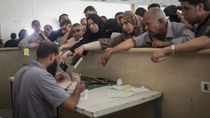 Des Palestiniens se rassemblent à la frontière de Rafah, dans le sud de la bande de Gaza, où ils attendent l'autorisation d'entrer en Egypte, le 12 juin 2015. (Crédit : AAED Tayeh/Flash90)